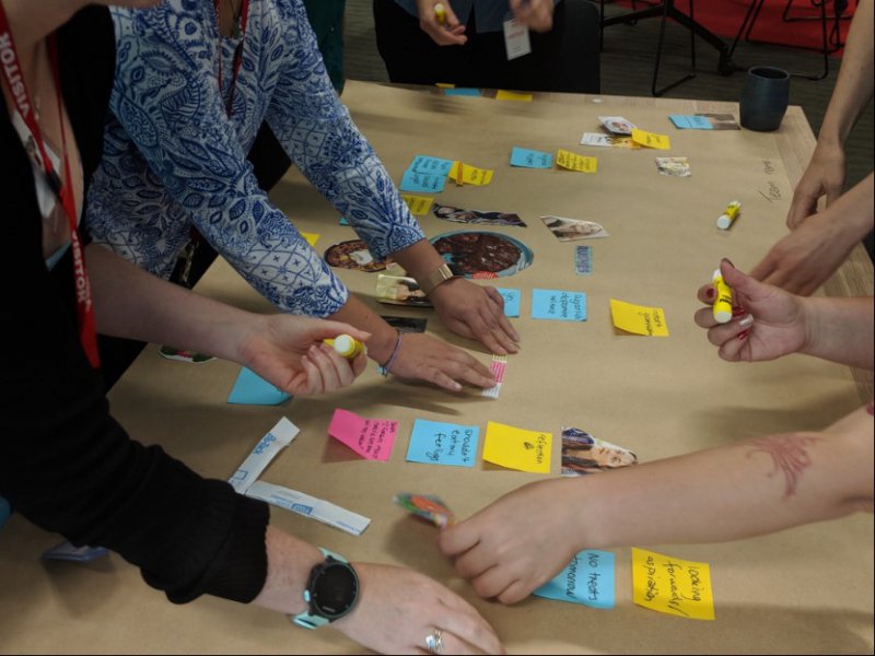 Hands moving post-it notes on a workshop table